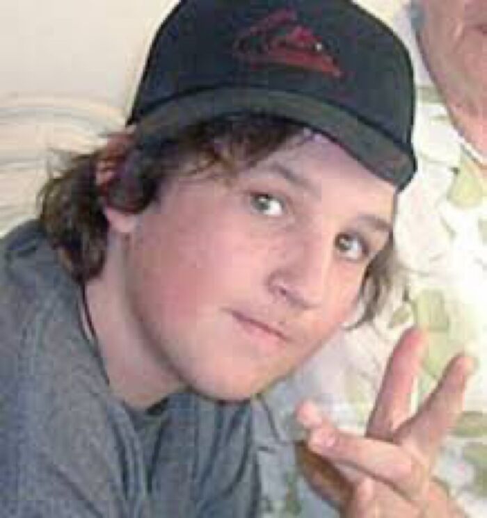 Young person wearing a black cap making a hand gesture, part of unsettling images from Morbid Knowledge online group.