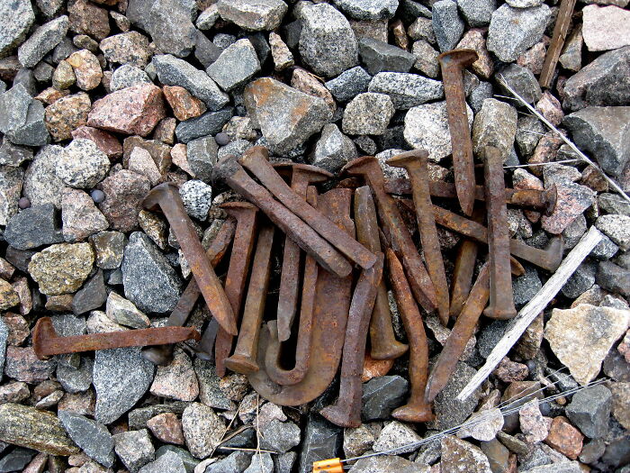 Rusty old nails scattered on rough gravel, illustrating unexpected discoveries like those by snooping parents. - 21