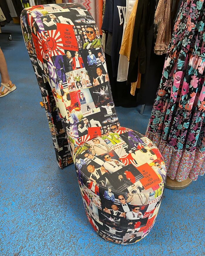 Thrift store find of a high-heeled chair covered in bizarre Gangnam Style print fabric among clothing racks.