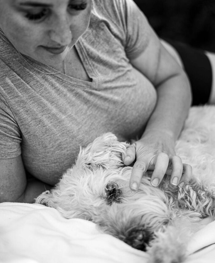 Woman tenderly holding and touching her dog's face, capturing a touching moment between pets and their humans.