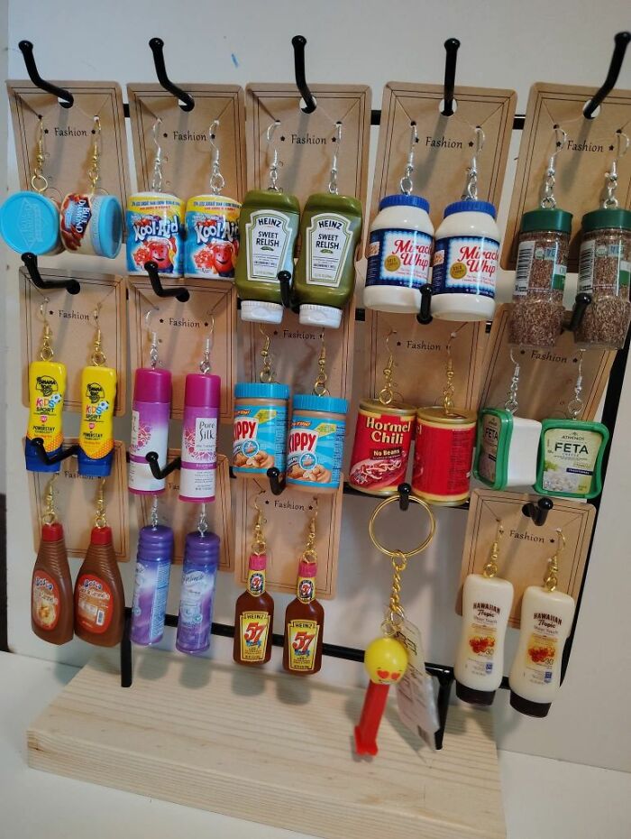 Miniature condiment and product keychain DIY crafts displayed on a stand, showcasing horrendous DIY projects to be craft shamed.