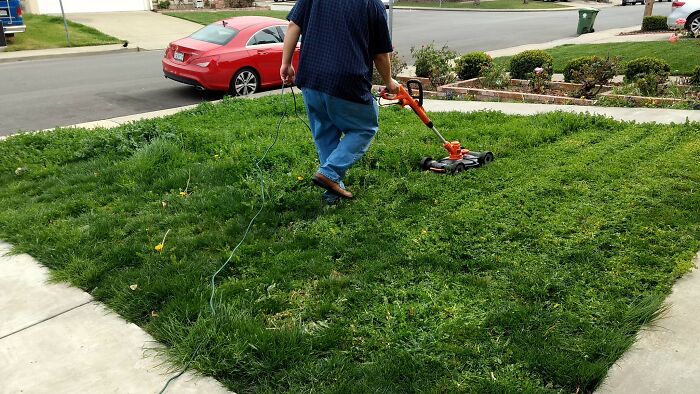 Person mowing the lawn with an electric mower, highlighting an unexpected item for wedding registries like a coffin.