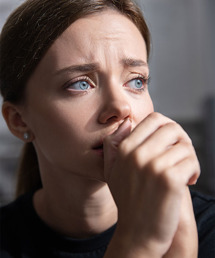 Woman with worried expression reacts after finding a mysterious sock at home, showing shock and concern.