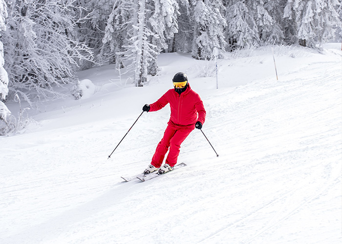 Person skiing down a snowy slope wearing red gear, illustrating moments rich people realized their unique lifestyle differences. - 5