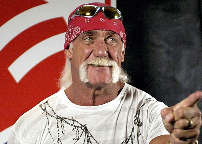 Wrestler in a red bandana and white shirt smiling and pointing, captured during a celebrity encounter experience.