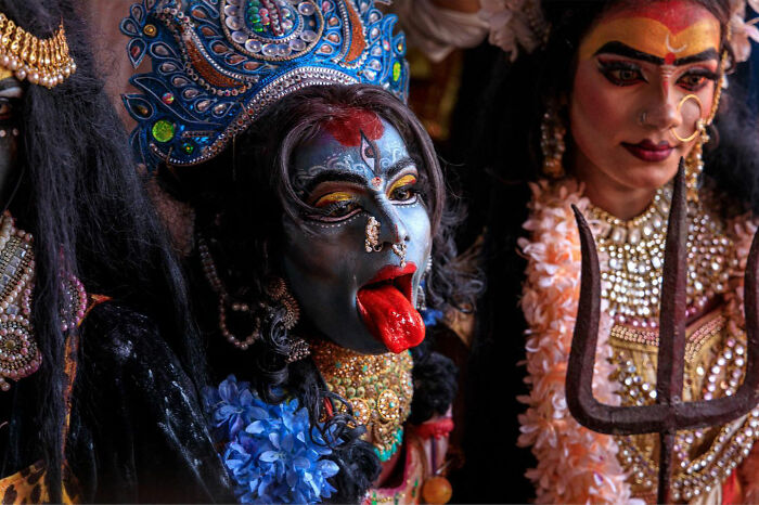 Candid everyday moment in Asia showing a person with traditional face paint and costume during a cultural event.