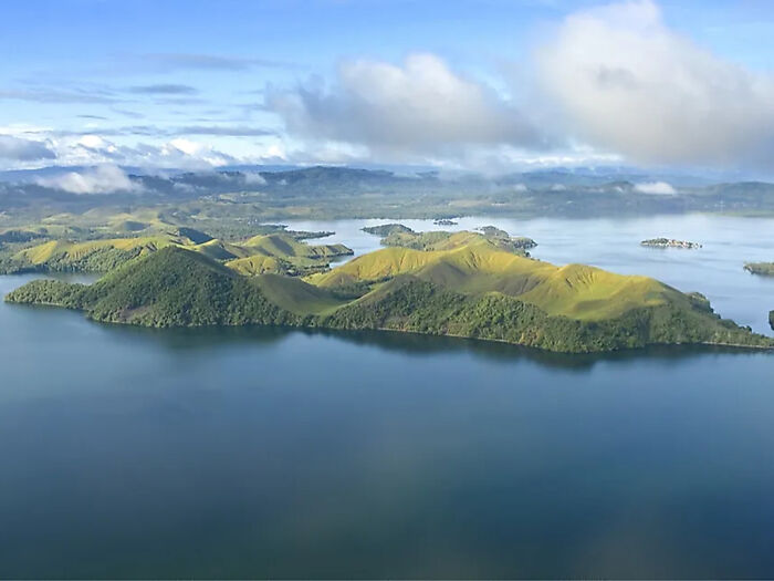 Aerial view of lush green islands surrounded by calm water, related to influencer sparks outrage filming Indigenous tribe.