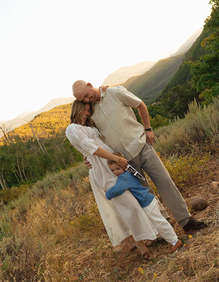 Family embracing outdoors in a scenic mountainous area, related to momfluencer's public statement on tragic drowning incident.