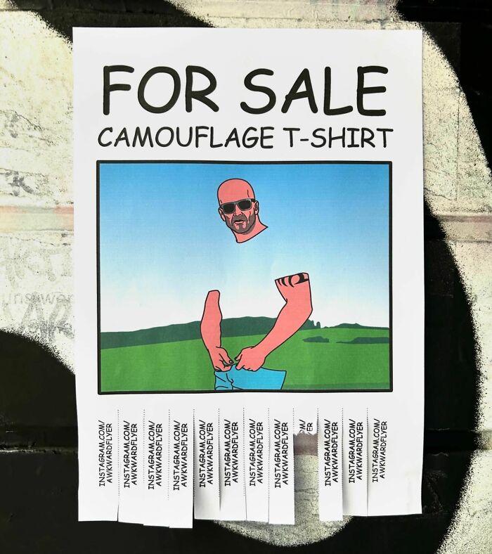 Street art photo of a clever camouflage T-shirt sign with peeling tabs against an outdoor background.