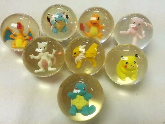Clear marbles containing 90s kids nostalgia Pokemon figurines including Charizard, Squirtle, and Pikachu toys.