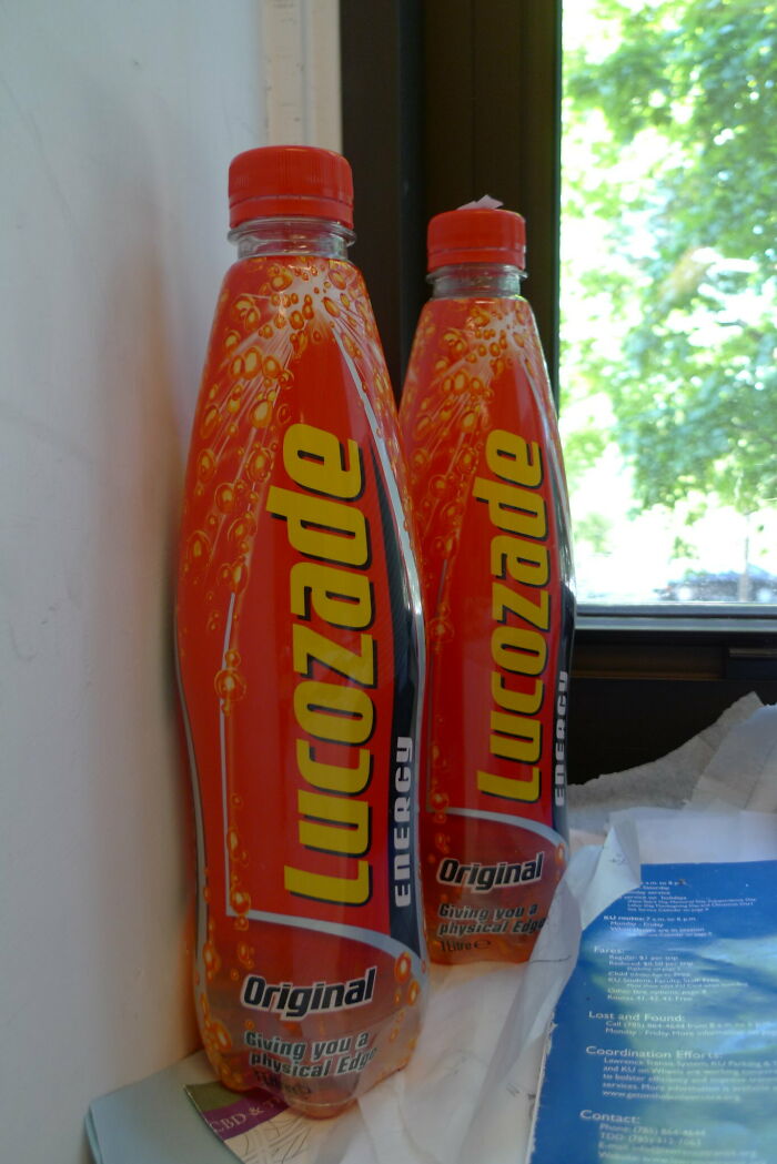 Two bottles of Lucozade energy drink on a windowsill next to papers, illustrating harmless secrets people haven’t told anyone.