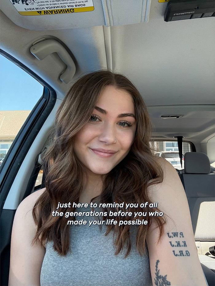 Young woman with long brown hair smiling in a car, inspiring others as a family historian to share their family tree online.