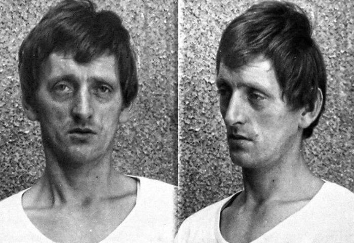 Black and white mugshot of a pale man with dark hair against a textured wall, unsettling image from morbid knowledge group.