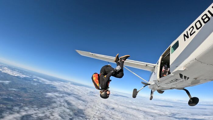 Woman in skydiving gear performing a 15,500-ft jump from a small airplane above the clouds after breakup choice Woman in skydiving gear performing a 15,500-ft jump from a small airplane above the clouds after breakup choice