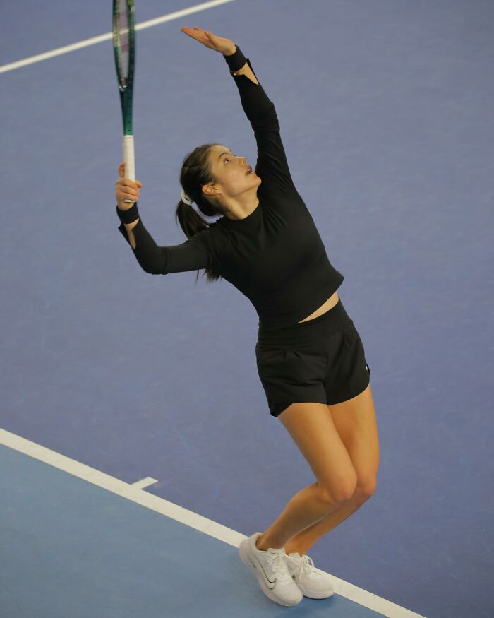Tennis star serving during a match, showing intense focus amid diva issues involving a sudden meltdown on court.