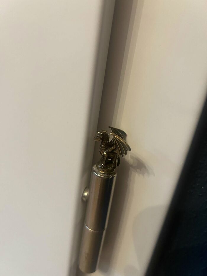 Small dragon decor piece perched on a metallic hinge, adding a magical touch to home decor elements.