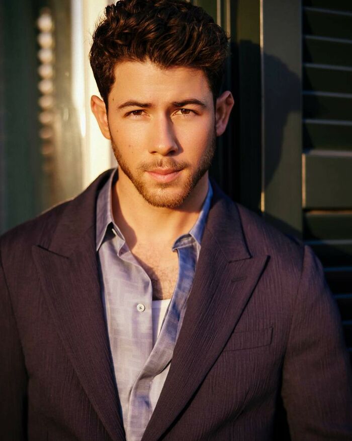 Nick Jonas in a casual blazer and shirt, revealing his thoughts about never sitting in bed with his wife sparking mixed reactions. Nick Jonas in a casual blazer and shirt, revealing his thoughts about never sitting in bed with his wife sparking mixed reactions.