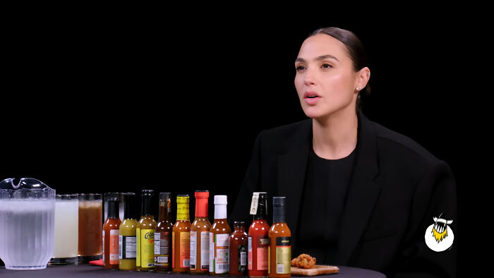 Gal Gadot, one of the celebrities Hollywood tried to make leading A-listers, seated at a table with hot sauces.