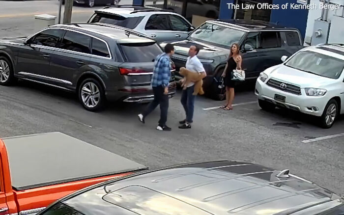 Uber driver confronts CEO outside cars, holding a service dog, in a parking lot during a shocking incident caught on video.