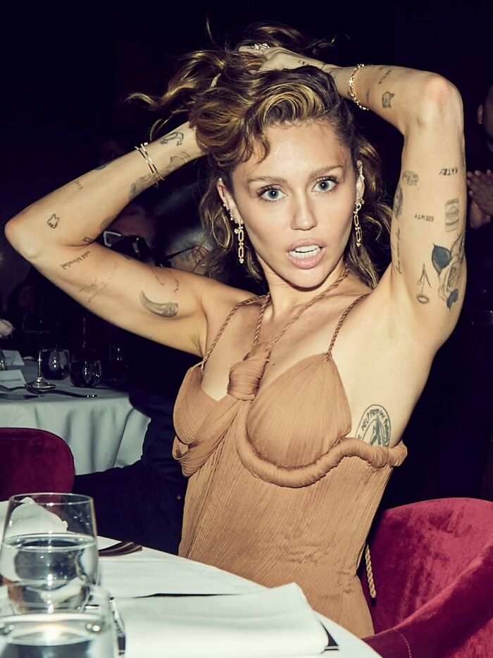 Miley Cyrus at a Gucci event with minimal eyebrows, sparking viral social media discussion about the eyebrow trend.