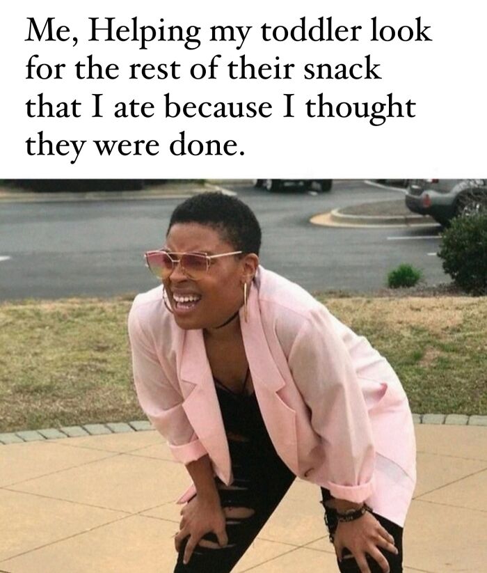 Parent bending forward in pink jacket squinting to find toddler's snack, capturing the humor of being a cool mom.