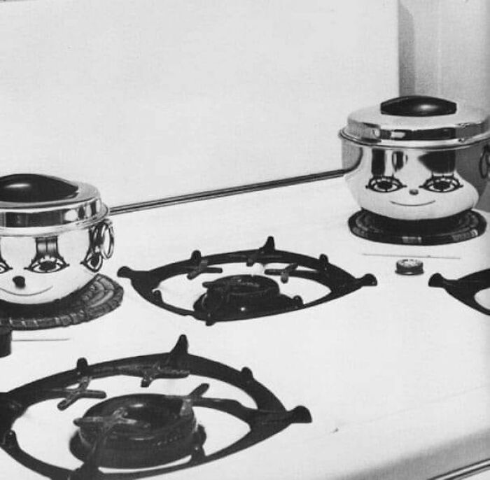 Two shiny pots on a stovetop with reflections that create faces, illustrating random objects looking like faces.