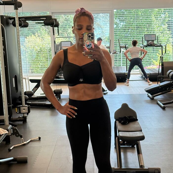 Serena Williams taking a gym mirror selfie in workout clothes showcasing weight loss transformation and fitness progress.