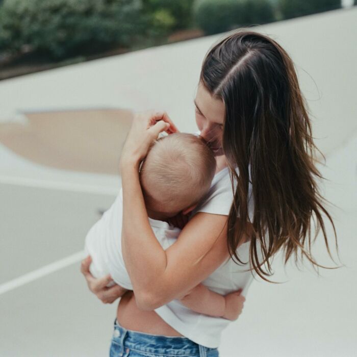 Young woman embracing a baby outdoors, illustrating the hidden factor behind Justin and Hailey Bieber’s troubled marriage. Young woman embracing a baby outdoors, illustrating the hidden factor behind Justin and Hailey Bieber’s troubled marriage.