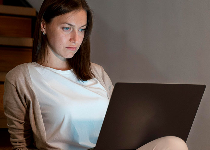 Focused woman using laptop indoors, illustrating man&rsquo;s petty revenge on entitled dog owner for SEO.