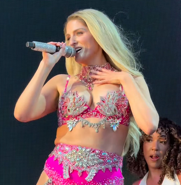 Meghan Trainor performing on stage in a sparkling pink outfit, looking stunning and unrecognizable to fans.