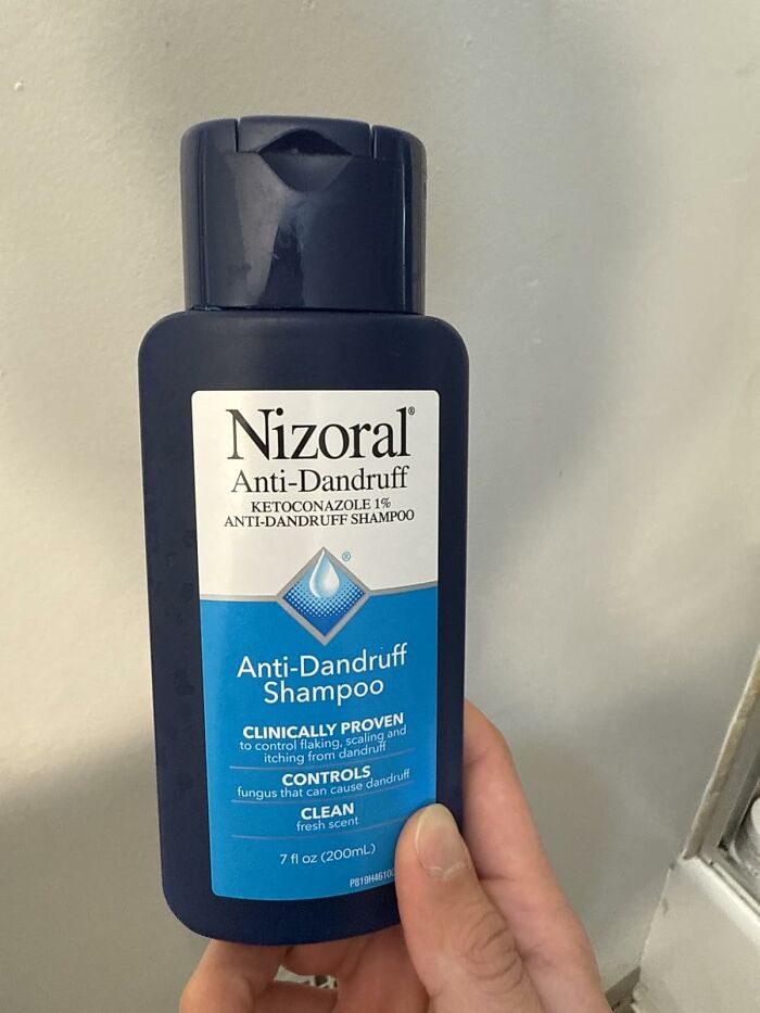 Bottle of Nizoral anti-dandruff shampoo held by a hand, featured in Amazon best seller list products worth the hype.