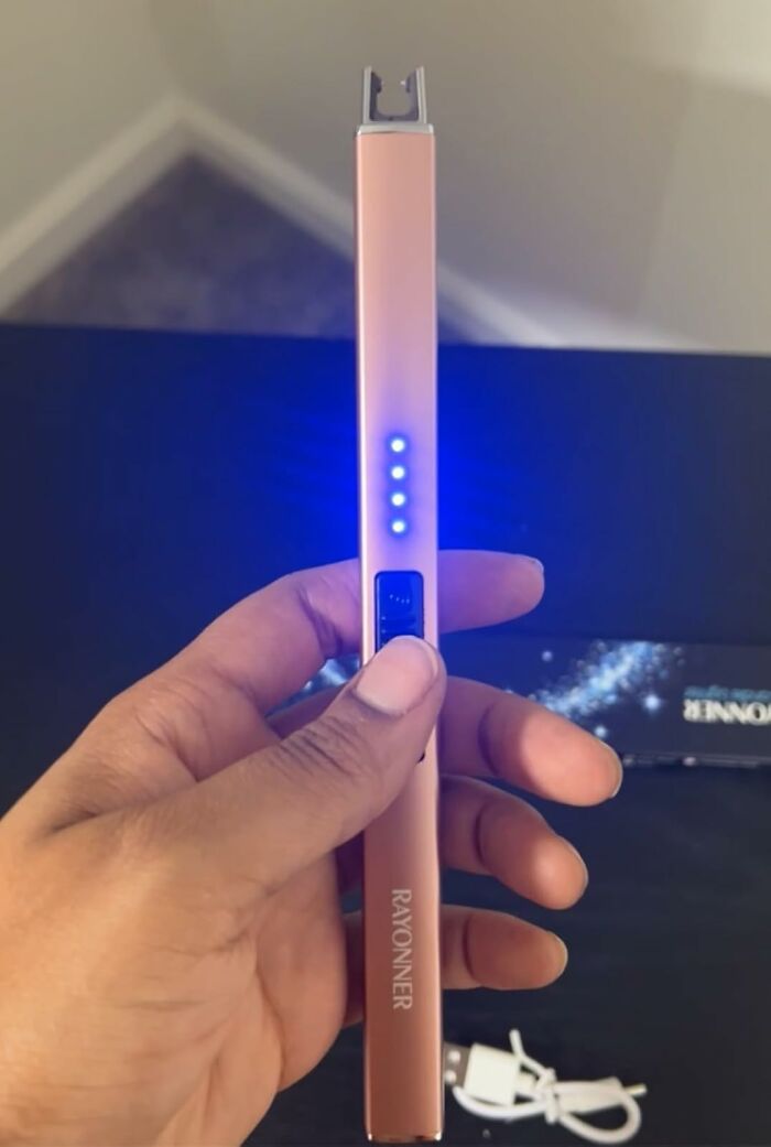 Hand holding a Rayonner electronic device with blue lights on, one of the most add to cart worthy finds trending on Amazon.