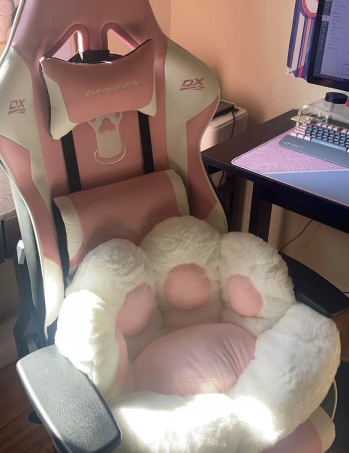 Pink and white gaming chair with a fluffy paw-shaped cushion, a sneakily useful decor item for home or office comfort.