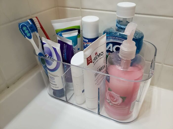Organized bathroom essentials in a clear plastic container showcasing low-lift, high-impact bathroom improvements.