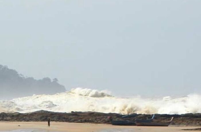Large crashing waves on a rocky shore with a lone person and boat, evoking morbid knowledge unsettling imagery.