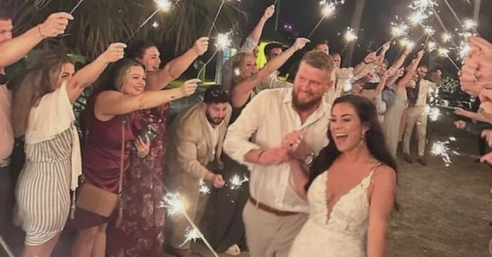 Wedding couple celebrating with sparklers surrounded by guests in an unsettling image from Morbid Knowledge.