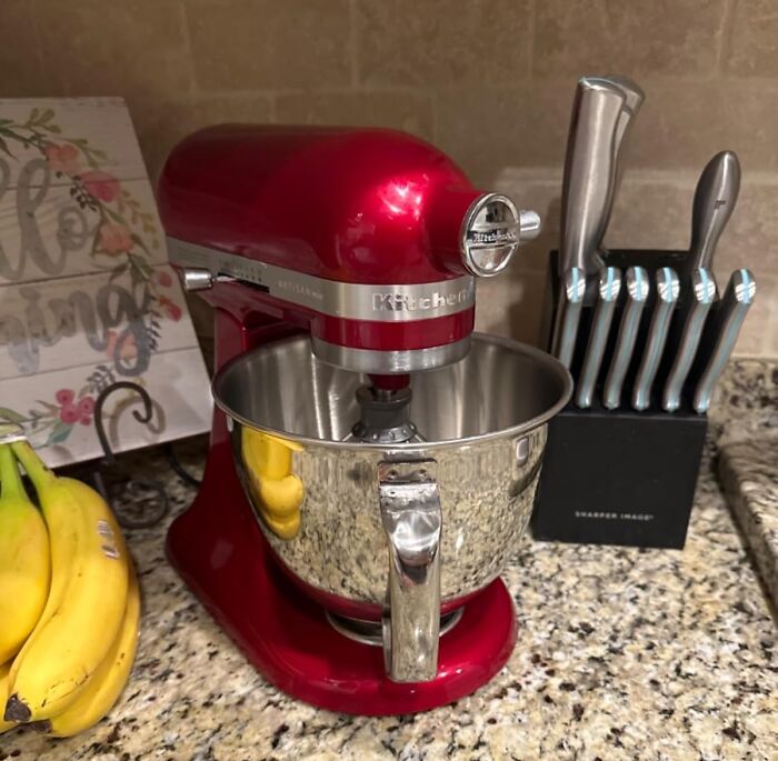 Red KitchenAid mixer on granite countertop next to a knife block and bananas, demonstrating clever kitchen problem-solvers.