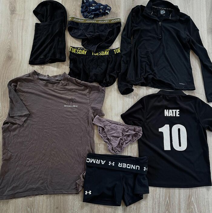 Laundry items laid out on a floor, highlighting clothes that a cat frequently steals from the neighborhood. - 8