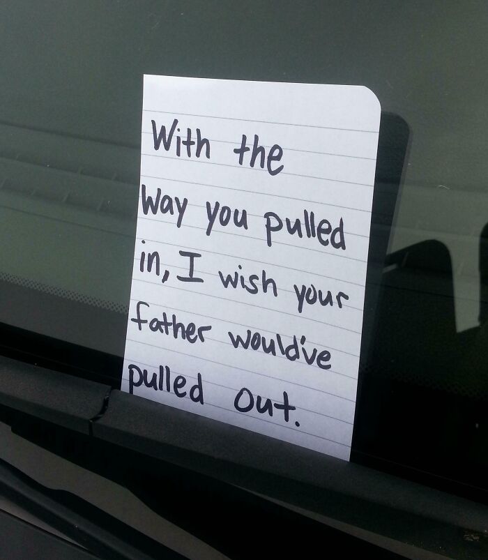 Handwritten unhinged neighbors’ note placed on a car windshield expressing frustration over parking.