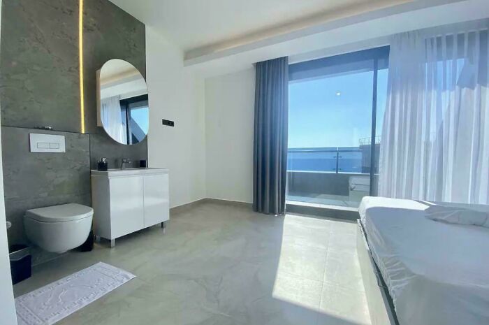 Minimalist bedroom with toilet in the same room and ocean view balcony, one of the weirdest things seen in someone else’s home - 7