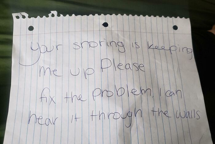 Handwritten unhinged neighbors’ note complaining about snoring heard through walls in shared living space.