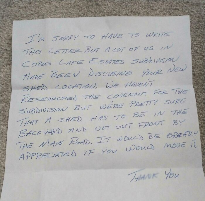 Handwritten neighbor's note about shed location rules, showcasing unhinged neighbors’ notes in shared living spaces.