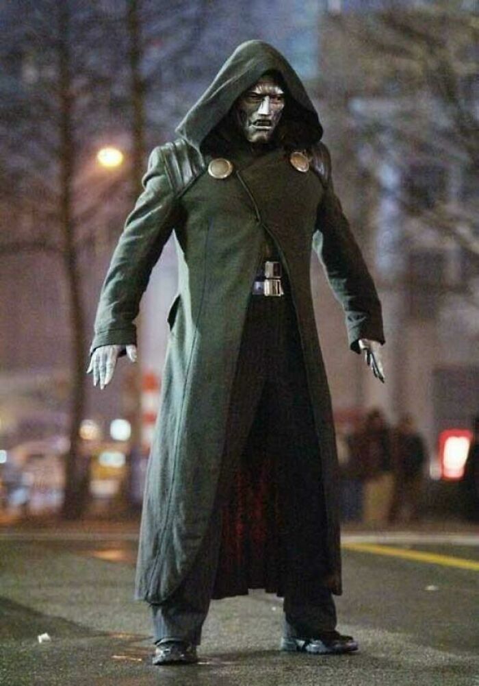 Character in a hooded coat with a metallic face mask standing on a city street, illustrating bad movie details and confusing scenes.