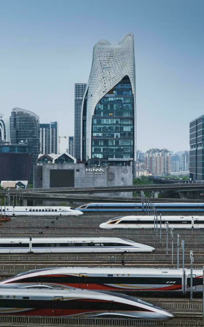 High-speed trains passing through a city with modern buildings showcasing brilliant infrastructure and urban development.