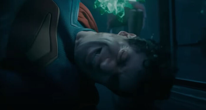 Actor in a superhero costume lying on the ground in a dark scene, showcasing bad movie details and confusing moments.