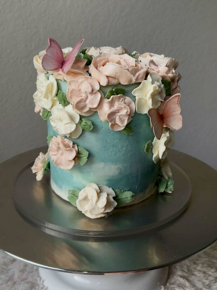 Decorated cake with pastel flowers and butterflies showcasing gorgeous baked goods and baking artistry.
