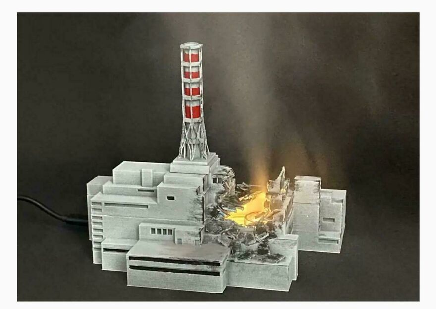 Humidificador del desastre de Chernobyl en miniatura con luz simulando el reactor da&ntilde;ado en un fondo oscuro.