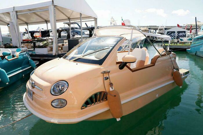 Boat designed to look like a small car docked in a marina, an example of awful taste but great e*******n.