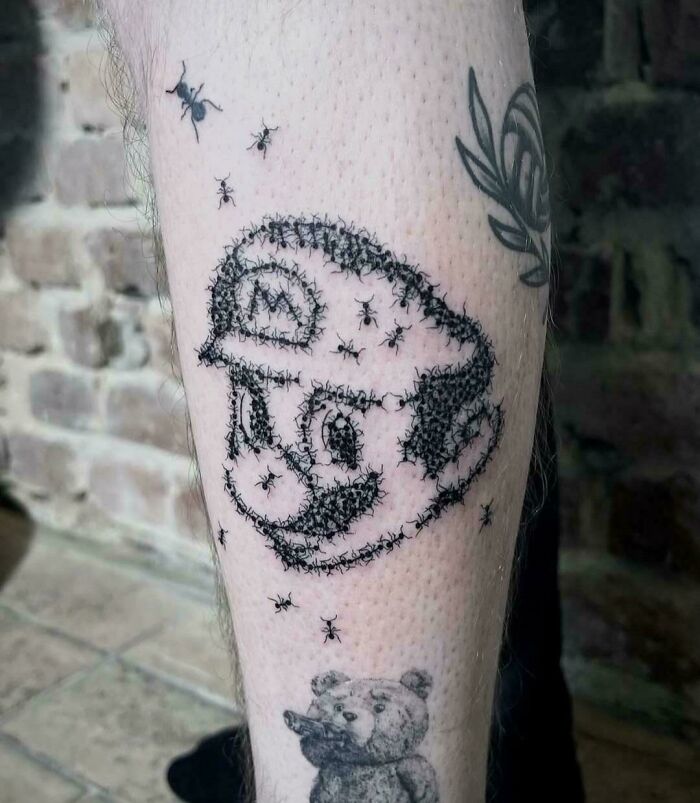 Tattoo of Mario made entirely of small black ants on a person's leg, showcasing awful taste but great e*******n.