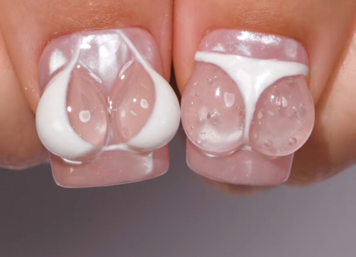 Close-up of nails with 3D clear gel nail art shaped like swimwear, an example of awful taste but great e*******n.
